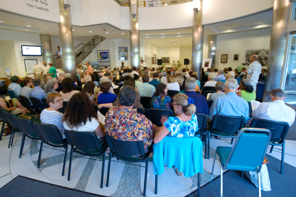 Crowd of individuals attending an event in the California State Library building. 